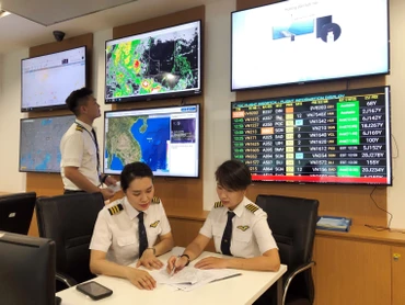 Cơ trưởng máy bay A350 Nguyễn Ly Hương (bên phải) trao đổi, chia sẻ kinh nghiệm bay với đồng nghiệp.