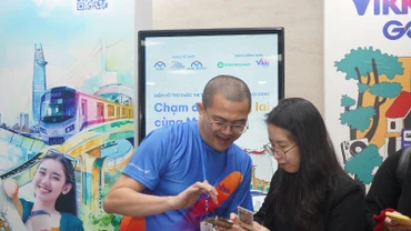 Nhân viên Ngân hàng hỗ trợ hành khách làm thẻ đi Metro số 1 miễn phí tại các nhà ga trên hành trình. (Ảnh: Thế Anh) 