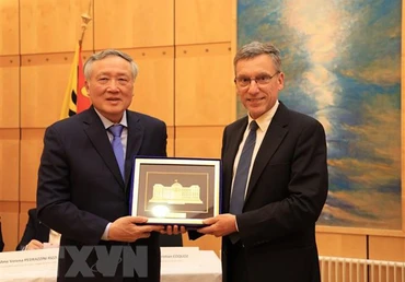 Chánh án Tòa án Nhân dân Tối cao Nguyễn Hòa Bình (trái) tặng quà lưu niệm cho ông Christian Coquoz, Chánh án Tòa án bang Geneva. (Ảnh: TTXVN)