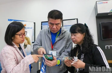 Người dân đi chuẩn hóa thông tin thuê bao di động sau khi nhận được tin nhắn thông báo. Ảnh: NHẬT QUANG.