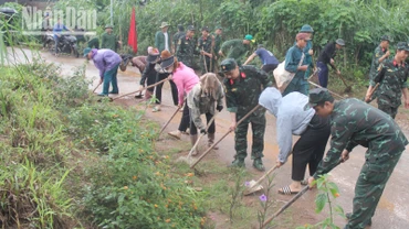 Các lực lượng và người dân các bản tham gia dọn dẹp, phát quang cỏ hai bên đường. 