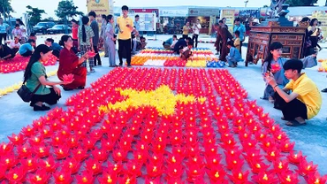 Người dân thắp nến tạo hình lá cờ Tổ quốc tại Chương trình. (Ảnh: XUÂN TRƯỜNG)