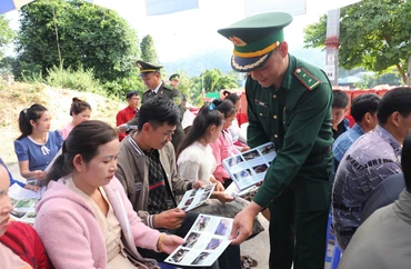 Cán bộ, chiến sĩ Bộ đội Biên phòng tỉnh Điện Biên phát tờ rơi tuyên truyền bảo vệ rừng đến nhân dân trên khu vực biên giới Việt-Lào.