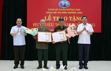 Đồng chí Trần Quốc Cường, Bí thư Tỉnh ủy Điện Biên và đồng chí Mùa A Sơn, Phó Bí thư Thường trực Tỉnh ủy Điện Biên tặng hoa, chúc mừng 2 chiến sĩ Điện Biên vinh dự được nhận Huy hiệu 70 năm tuổi Đảng.