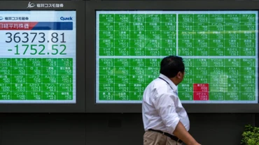 Một người đi bộ ngang qua màn hình hiển thị thông tin thị trường chứng khoán tại Tokyo, Nhật Bản, ngày 2/8/2024. (Ảnh minh họa: Tân Hoa xã)