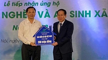 Phó Tổng Giám đốc Bảo hiểm xã hội Việt Nam Chu Mạnh Sinh (trái) trao 200 triệu đồng ủng hộ Quỹ Vì người nghèo năm 2022. (Ảnh: VSS)