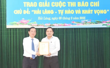 Trưởng Ban Tuyên giáo và Dân vận Tỉnh ủy Quảng Trị Hồ Đại Nam (bên trái) trao giải A cho tác giả.