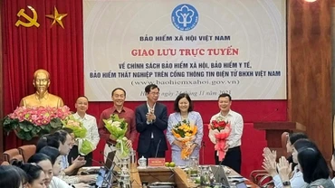 Phó Tổng Giám đốc Bảo hiểm xã hội Việt Nam Đào Việt Ánh tặng hoa khách mời, chuyên gia tham dự giao lưu trực tuyến vào tháng 11/2023. (Ảnh: TÂM TRUNG)
