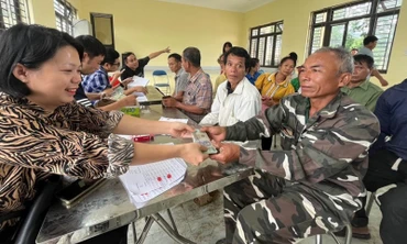 Cán bộ Công ty Cổ phần Cao-su Điện Biên chi trả tiền góp đất cho các hộ dân trên địa bàn huyện Mường Chà.