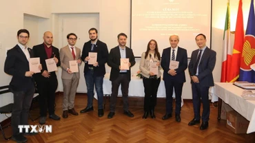 Đại sứ Việt Nam tại Italia Dương Hải Hưng trao tặng bản dịch tiếng Italia cuốn sách “Lý luận và thực tiễn con đường đi lên Chủ nghĩa xã hội của Việt Nam” của Tổng Bí thư Nguyễn Phú Trọng cho các đại biểu. (Ảnh: TTXVN)