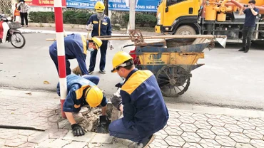 Công nhân Công ty Thoát nước Hà Nội nạo vét hệ thống thoát nước.