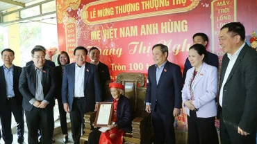 Đồng chí Nguyễn Xuân Thắng trao thiếp mừng thọ tròn 100 tuổi của Chủ tịch nước cho Mẹ Việt Nam Anh hùng Hoàng Thị Nghi.
