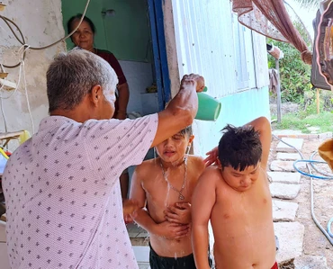 Bé Tuấn Khải, Tuấn Quy (ấp Minh Hà B) được người nhà dội rửa lại bằng ít nước ngọt sau khi tắm nước mặn dưới vuông tôm.