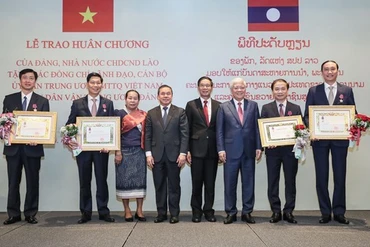 Chủ tịch Ủy ban Trung ương Mặt trận Lào xây dựng đất nước Sinlavong Khoutphaythoune và Chủ tịch Ủy ban Trung ương MTTQ Việt Nam Đỗ Văn Chiến chụp ảnh lưu niệm với các cá nhân được nhận Huân chương Ít-xa-la hạng II, III 