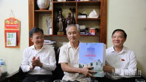 Đồng chí Nguyễn Khắc Định, Phó Chủ tịch Quốc hội (bên phải) tặng quà thương binh Phạm Văn Lương, thôn Minh Hòa, xã Vũ Thư (tỉnh Hưng Yên).