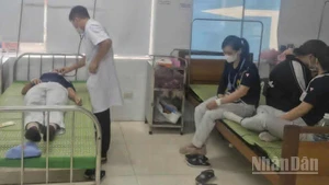 Bác sĩ Bệnh viện đa khoa Tiền Hải (tỉnh Hưng Yên) thăm khám cho nữ công nhân Công ty Toyoda (Nhật Bản) sau khi dùng bữa trưa tại nhà máy, ngày 7/8/2025.