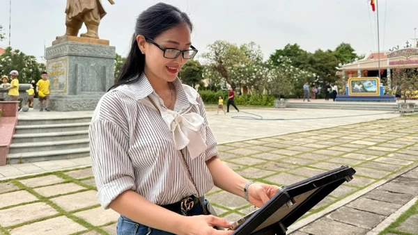 Cô giáo Trần Thị Bích Phương check-in bảng gắn chip NFC thuộc Dự án "Yêu lắm Việt Nam" của Báo Nhân Dân tại Di tích Đền thờ Nguyễn Hữu Cảnh.