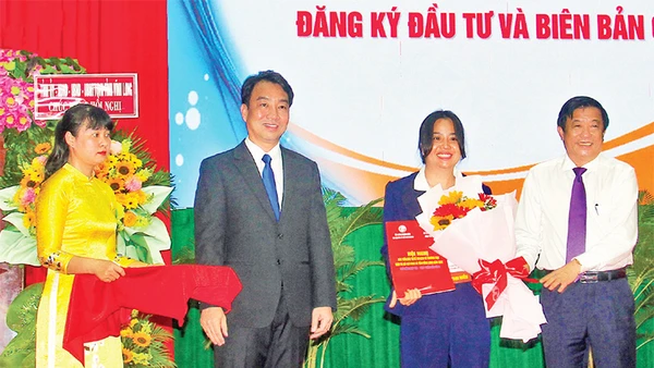 Lãnh đạo tỉnh Vĩnh Long trao giấy chứng nhận cho các nhà đầu tư. (Ảnh BÁ DŨNG)