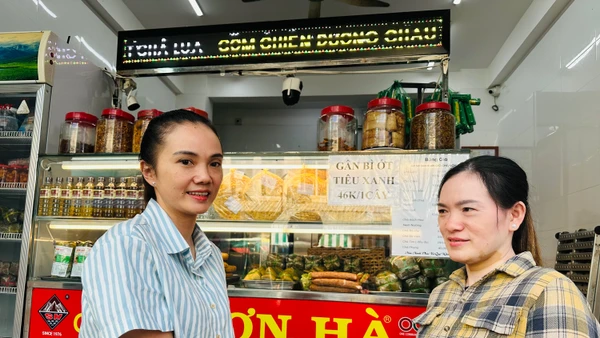 Hộ gia đình chị Phạm Tuyết Linh (bên trái), cơ sở sản xuất bánh mì và chả lụa Sơn Hà nổi tiếng hơn 40 năm qua tại Bạc Liêu ký cam kết với cơ quan chức năng thực hiện nghiêm các biện pháp an toàn thực phẩm trong dịp Tết. (Ảnh: TRỌNG DUY)