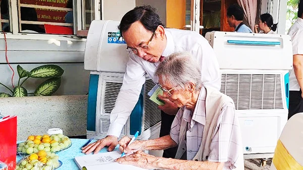 Nhạc sĩ Lư Nhất Vũ ký tặng sách cho đồng chí Bí thư Thành ủy Thành phố Hồ Chí Minh Nguyễn Văn Nên. Ảnh: TRỊNH BÌNH