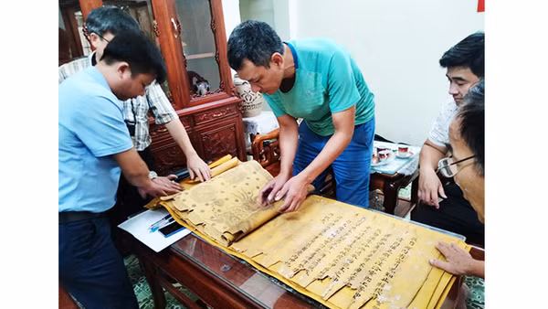 Nhà sưu tập Đặng Vũ Khương cùng đại diện người dân Tri Chỉ kiểm tra tình trạng sắc phong. Ảnh: NCVV