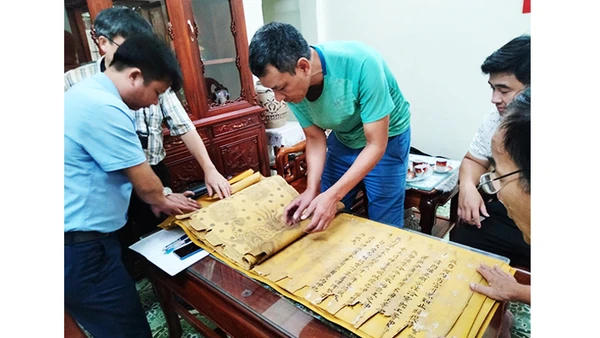Nhà sưu tập Đặng Vũ Khương cùng đại diện người dân Tri Chỉ kiểm tra tình trạng sắc phong. Ảnh: NCVV