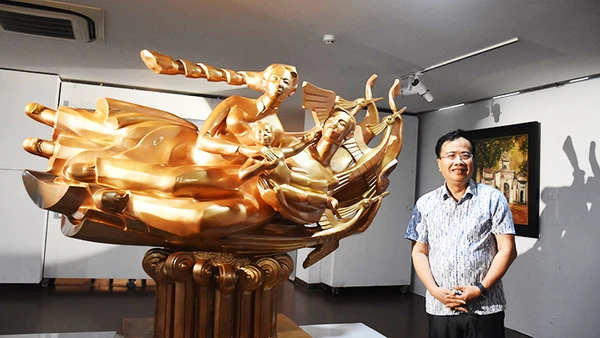 Họa sĩ, nhà điêu khắc Đinh Gia Thắng bên tác phẩm điêu khắc “Cội nguồn hạnh phúc”.