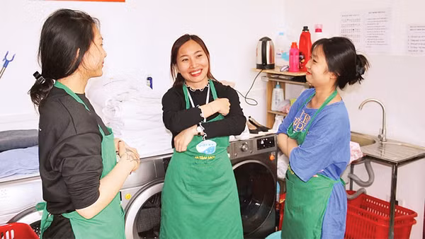 Lương Thị Kiều Thúy (người đứng giữa) trao đổi công việc cùng các đồng nghiệp. 