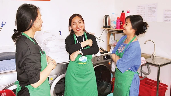 Lương Thị Kiều Thúy (người đứng giữa) trao đổi công việc cùng các đồng nghiệp. 