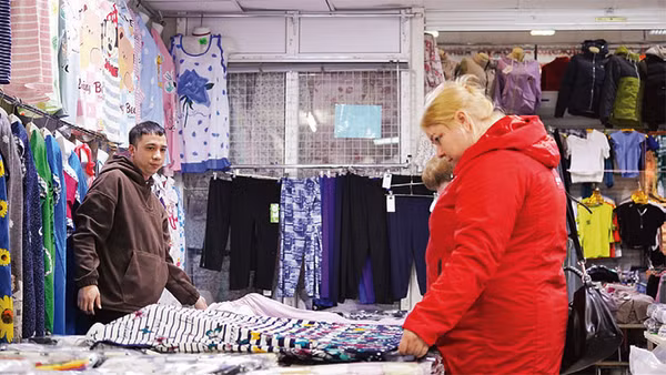 Quân bán hàng trong chợ.