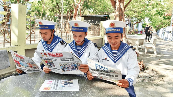 Các chiến sĩ trên đảo Trường Sa (Khánh Hòa) đọc Báo Nhân Dân. Ảnh: ĐĂNG KHOA