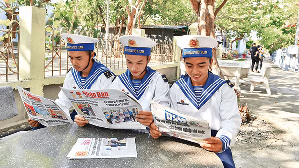 Các chiến sĩ trên đảo Trường Sa (Khánh Hòa) đọc Báo Nhân Dân. Ảnh: ĐĂNG KHOA