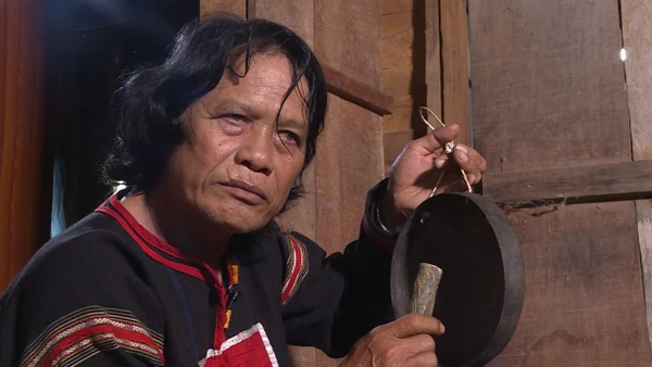 Nghệ nhân Nay Phai đang thử độ ngân khi chỉnh chiêng. (Ảnh: NX)