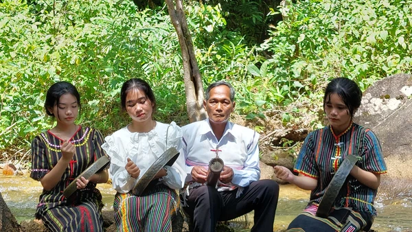 Nghệ nhân K’Trời dạy các cháu học sinh chơi cồng chiêng.