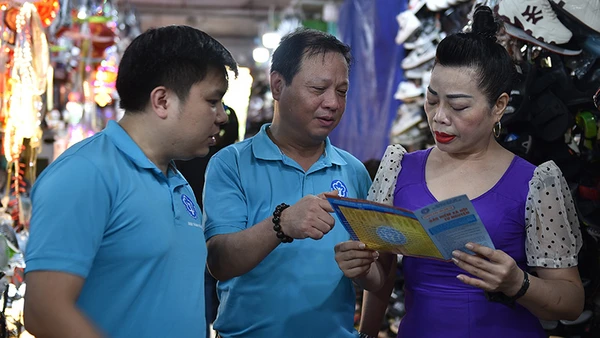 Cán bộ Bảo hiểm xã hội khu vực I vận động người dân tham gia bảo hiểm xã hội tự nguyện, bảo hiểm y tế hộ gia đình. (Ảnh HSS)