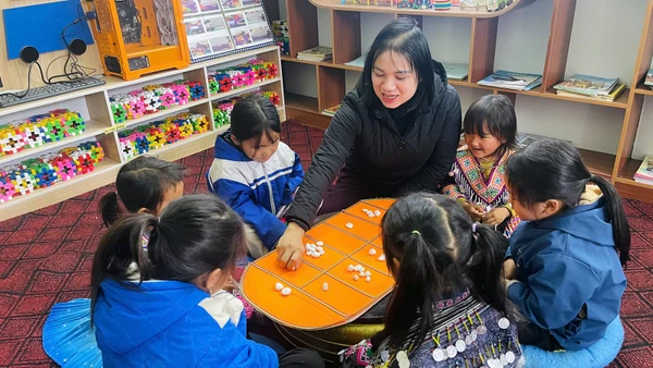Cô giáo Đỗ Thị Loan cùng học sinh Trường mầm non Kim Nọi trải nghiệm trò chơi dân gian "ô ăn quan" trong góc STEM của lớp. 