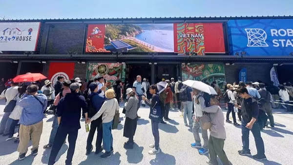 Khách tham quan xếp hàng vào thăm Nhà triển lãm Việt Nam tại EXPO 2025. 
