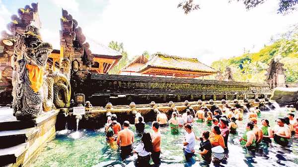 Người dân và du khách xếp hàng chờ đến lượt thực hiện nghi thức tắm nước suối thiêng ở đền Tirta Empul.
