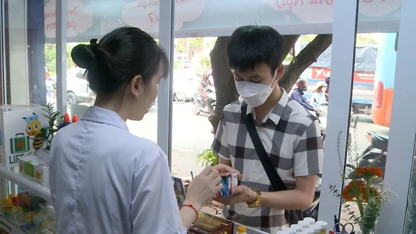 Nhân viên một cửa hàng thuốc tư vấn về thực phẩm chức năng cho người mua. (Ảnh: Thúy Quỳnh)