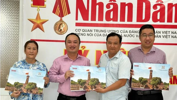 Văn phòng đại diện Báo nhân Dân tại tỉnh Bến Tre bàn giao tờ phụ san về Cột cờ Hà Nội cho Thư viện Nguyễn Đình Chiểu. (Ảnh: HOÀNG TRUNG)