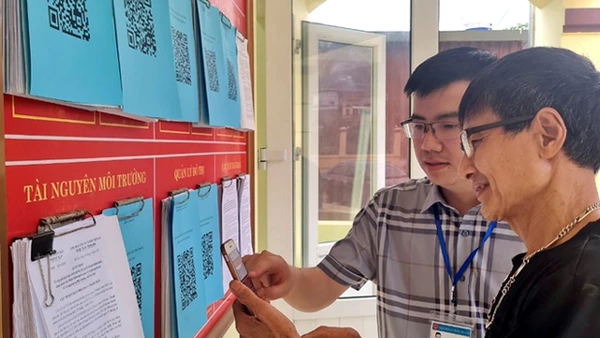 Hướng dẫn nhân dân quét mã QR để tra cứu thủ tục hành chính tại phường Sông Cầu, thành phố Bắc Kạn. (Ảnh: ĐĂNG BÁCH)
