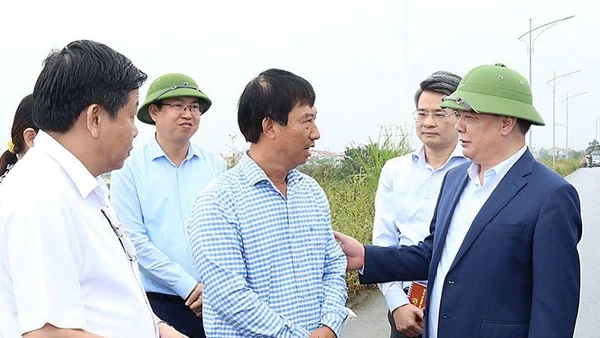 Đồng chí Đinh Tiến Dũng trò chuyện với người dân có đất nằm trong dự án Vành đai 4-Vùng Thủ đô trên địa bàn huyện Hoài Đức.