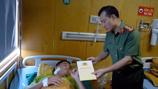 Lãnh đạo Công an tỉnh Yên Bái thăm, động viên thiếu tá Lương Văn Chiến. (Ảnh: THANH SƠN)