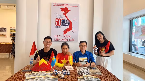 Khách tham quan triển lãm chụp ảnh cùng các tác phẩm về tình yêu Tổ quốc.