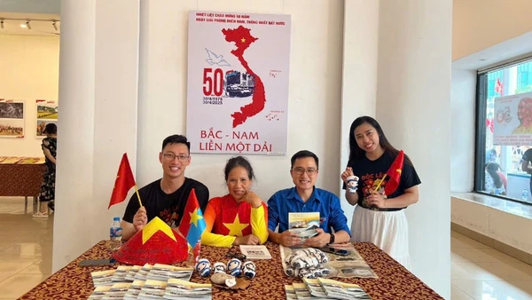 Khách tham quan triển lãm chụp ảnh cùng các tác phẩm về tình yêu Tổ quốc.