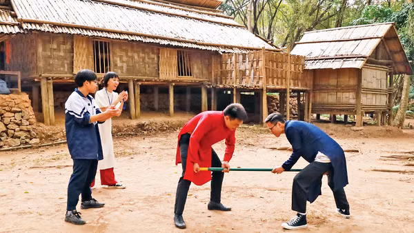 Khách tham quan tham gia trò chơi gậy của người dân tộc Mông. 