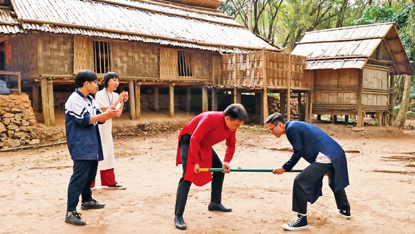 Khách tham quan tham gia trò chơi gậy của người dân tộc Mông. 