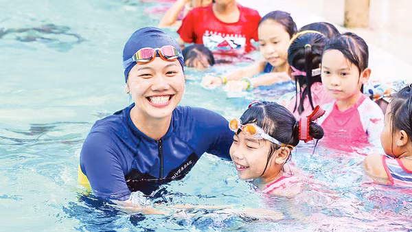 Ánh Viên hỗ trợ dạy bơi miễn phí cho các em nhỏ trong chương trình phòng chống đuối nước. Ảnh: Minh Tân 