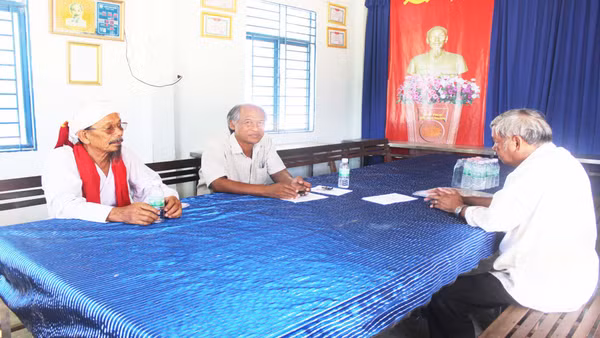 Ông Quảng Đại Thính (mặc áo vải ca-rô, giữa ảnh) gặp các bô lão trong làng để vận động xóa bỏ hủ tục lạc hậu, xây dựng đời sống văn minh.