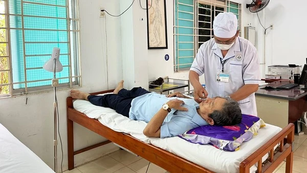 Y sĩ Nguyễn Hữu Đức điều trị cho bệnh nhân (Ảnh: NGUYỄN TRUNG)